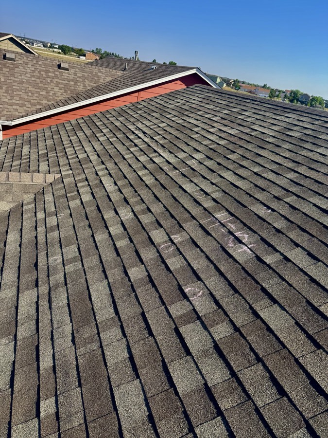 Hail hits marked on shingles during an inspection