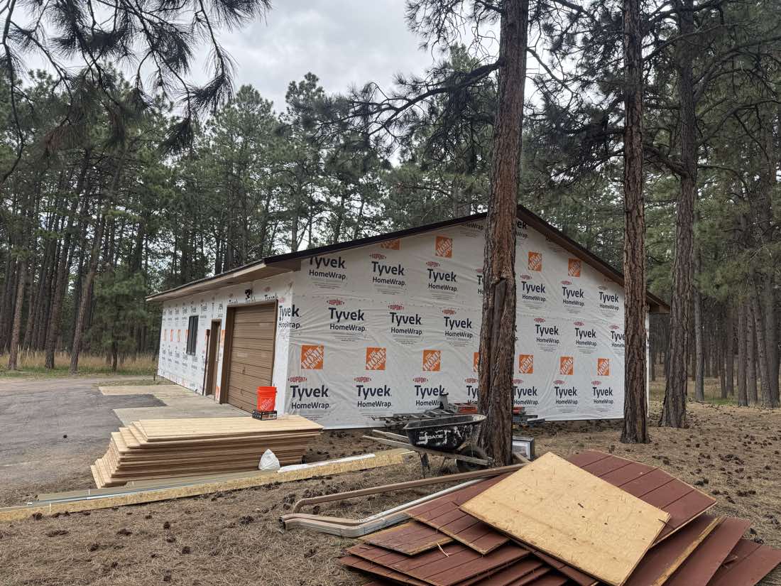 Detached garage with new house wrap during a siding replacement